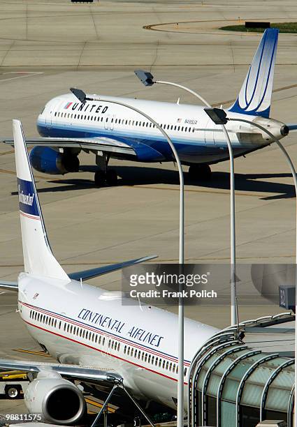 United Airlines jet taxis from the gate as a Continental Airlines plane sits at a gate at O'Hare International Airport May 3, 2010 in Chicago,...