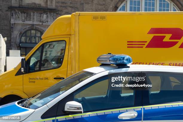 uma van de entrega dhl estacionada atrás de um carro de polícia em hamburgo, alemanha - infrações de estacionamento - fotografias e filmes do acervo