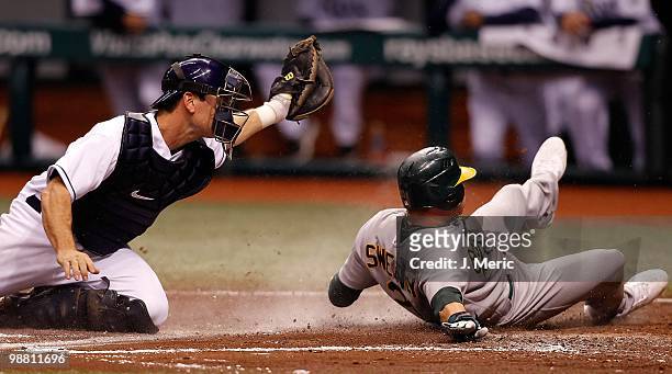 Catcher John Jaso of the Tampa Bay Rays is late with the tag as outfielder Ryan Sweeney of the Oakland Athletics is safe during the game at Tropicana...