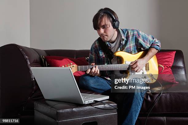 man plays electric guitar with lap top - guitarra elétrica - fotografias e filmes do acervo