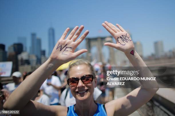 Demonstrators cross the Brooklyn Bridge during a march against the separation of immigrant families, on June 30, 2018 in New York. - Demonstrations...