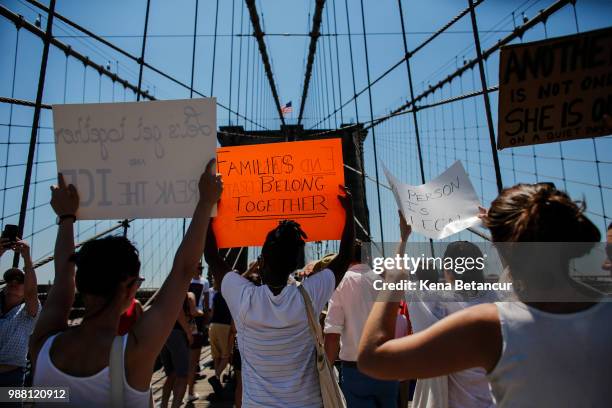 People take part in the nationwide "Families Belong Together" march as they walk over the Brooklyn Bridge on June 30, 2018 in New York City. As...