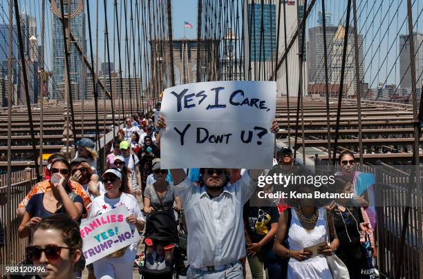 People take part in the nationwide "Families Belong Together" march as they walk over the Brooklyn Bridge on June 30, 2018 in New York City. As...