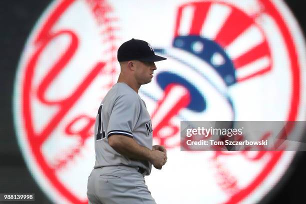 Brett Gardner of the New York Yankees warms up in the outfield with a team logo displayed on the auxiliary scoreboard behind him moments before the...