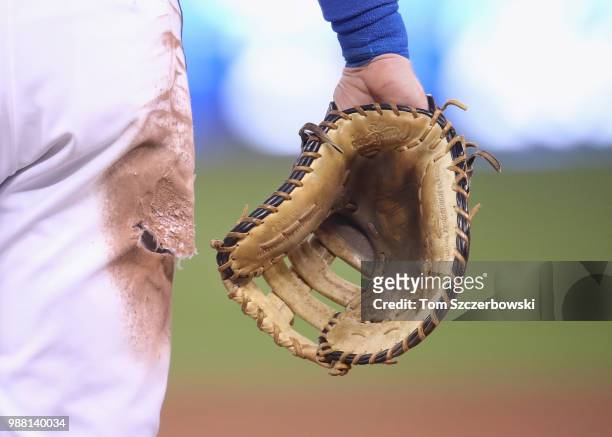 Detailed view of the glove and torn pants worn by Justin Smoak of the Toronto Blue Jays during MLB game action against the New York Yankees at Rogers...