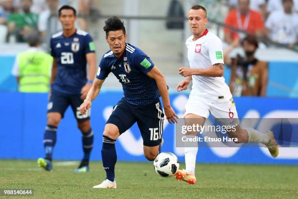 Hotaru Yamaguchi of Japan and Jacek Goralski of Poland compete for the ball during the 2018 FIFA World Cup Russia group H match between Japan and...
