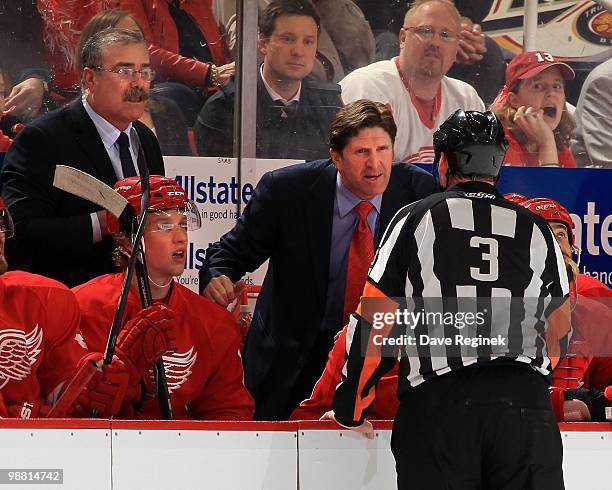 Head coach Mike Babcock and assistant coach Paul MacLean of the Detroit Red Wings talks with referee Mike Leggo during a stopage in play in Game Four...