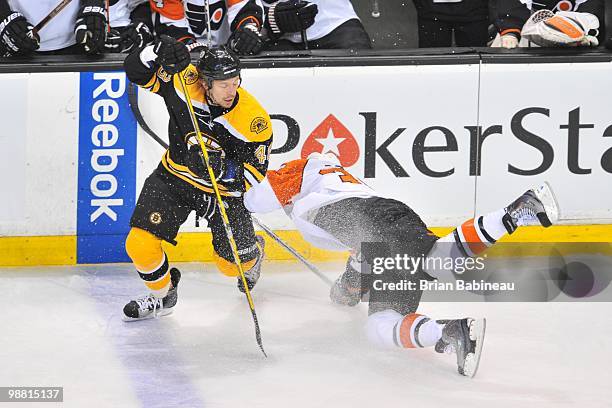 Matt Hunwick of the Boston Bruins checks Darroll Powe of the Philadelphia Flyers in Game One of the Eastern Conference Semifinals during the 2010 NHL...