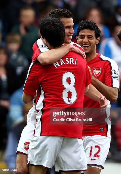 Robin Van Persie of Arsenal celebrates with team mates Samir Nasri and Carlos Vela after scoring the first goal during the Barclays Premier League...