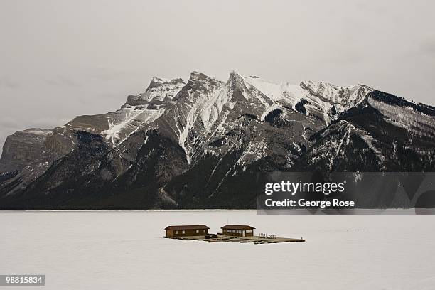 Boathouse stands locked in ice on a frozen Lake Minnewanka as seen in this 2010 Banff Springs, Canada, early evening landscape photo.