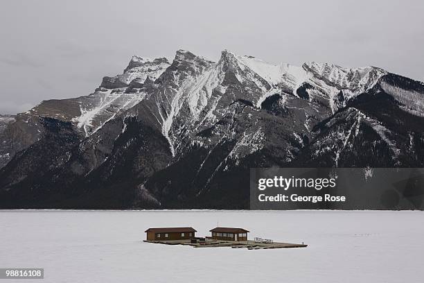 Boathouse stands locked in ice on a frozen Lake Minnewanka as seen in this 2010 Banff Springs, Canada, early evening landscape photo.