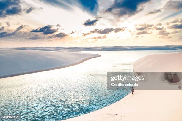 jovem homem caminhar sobre as dunas de areia de lençois maranhenses - lencois maranhenses national park - fotografias e filmes do acervo