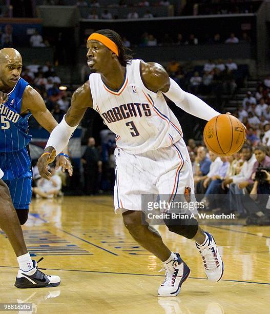 Gerald Wallace of the Charlotte Bobcats dribbles away from Vince Carter of the Orlando Magic at Time Warner Cable Arena on April 26, 2010 in...