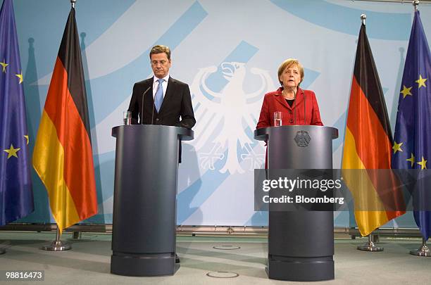 Angela Merkel, Germany's chancellor, right, and Guido Westerwelle, foreign affairs minister, hold a news conference at the German federal chancellory...