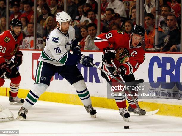 Jonathan Toews of the Chicago Blackhawks and Mikael Samuelsson of the Vancouver Canucks battle for the puck in Game One of the Western Conference...