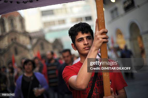 Leftist demonstrator carries a banner during a march in central Athens on May 3, 2010. Leading European stock exchanges on Monday shook off an early...