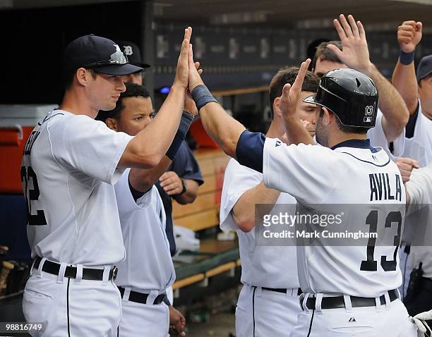 Don Kelly and Alex Avila of the Detroit Tigers high-five in the dugout against the Los Angeles Angels of Anaheim during the game at Comerica Park on...