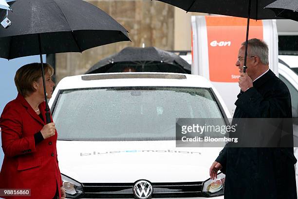 Angela Merkel, Germany's chancellor, left, stands with Martin Winterkorn, chef executive officer of Volkswagen AG, in front of an electric Volkswagen...