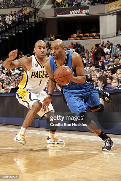 Vince Carter of the Orlando Magic dribble drives baseline against Dahntay Jones of the Indiana Pacers during the game at Conseco Fieldhouse on April...