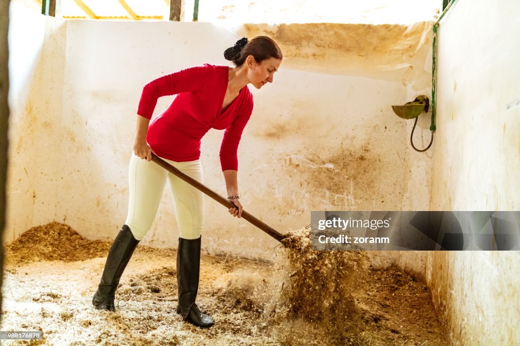 Woman tidying stable