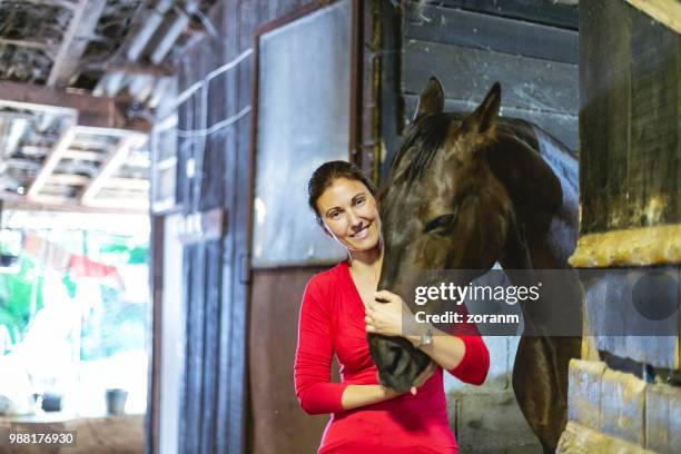glimlachend jockey strelen paard snuit - breeches stockfoto's en -beelden