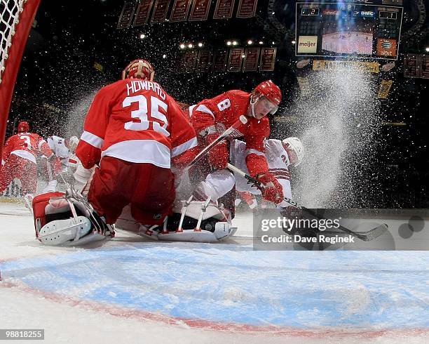 Vernon Fiddler of the Phoenix Coyotes skates hard to the net as Justin Abderkader of the Detroit Red Wings defends as teammate Jimmy Howard makes a...