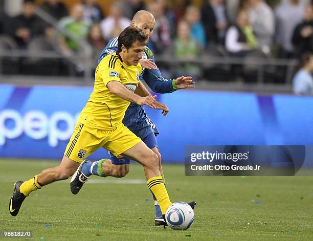 Guillermo Barros Schelotto of the Columbus Crew in action against Freddie Ljungberg of the Seattle Sounders FC on May 1, 2010 at Qwest Field in...