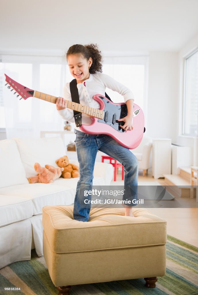 Hispanic girl playing guitar