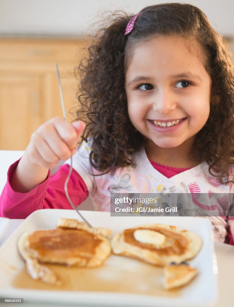Hispanic girl eating pancakes