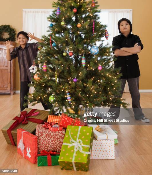 filipino boys in living room with christmas tree and gifts - gardena californië stockfoto's en -beelden