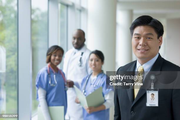 chinese businessman in hospital with doctors and nurses - terry fair stock pictures, royalty-free photos & images