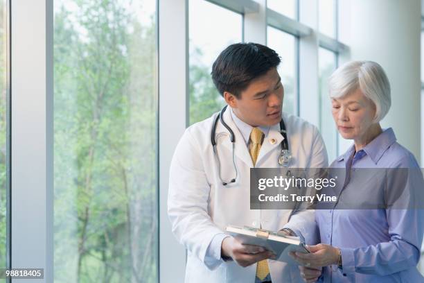 chinese doctor talking to woman - terry fair stock pictures, royalty-free photos & images