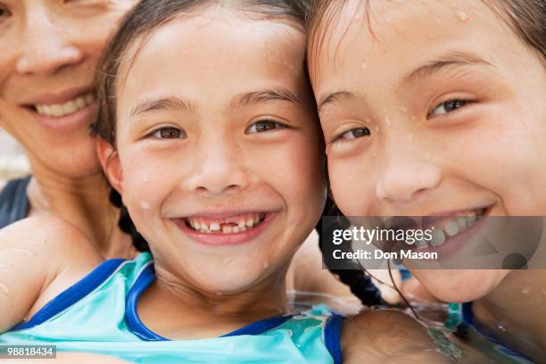 family in pool smiling - don mason stock pictures, royalty-free photos & images