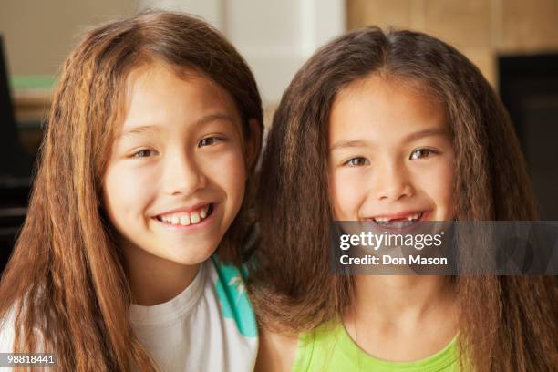 mixed race sisters smiling - don mason stock pictures, royalty-free photos & images