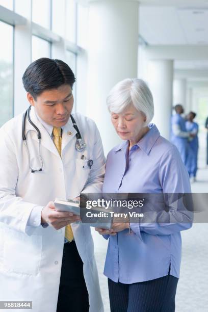 chinese doctor talking to woman - terry fair stock pictures, royalty-free photos & images