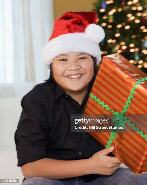 filipino boy holding christmas gift - gardena california fotografías e imágenes de stock