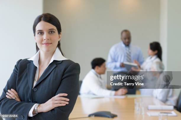 mixed race businesswoman in conference room with co-workers - terry fair stock pictures, royalty-free photos & images