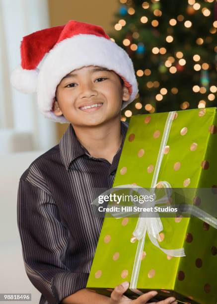 filipino boy holding christmas gift - gardena california fotografías e imágenes de stock