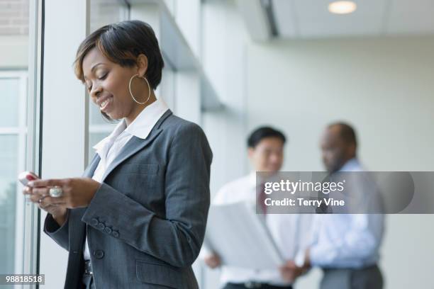 black businesswoman text messaging on cell phone - terry fair stock pictures, royalty-free photos & images