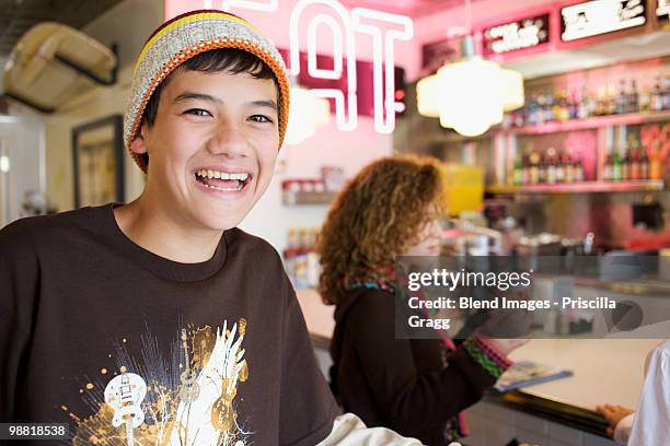 mixed race boy smiling in cafe - coronado island stockfoto's en -beelden