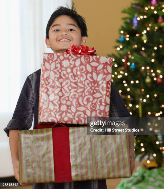 filipino boy holding christmas gifts - gardena californië stockfoto's en -beelden