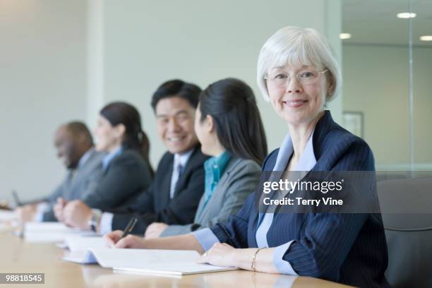 mixed race businesswoman in conference room with co-workers - terry fair stock pictures, royalty-free photos & images