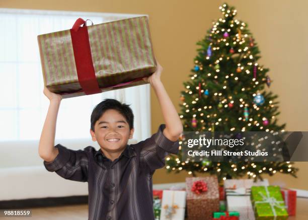 filipino boy holding christmas gift - filipino photos et images de collection