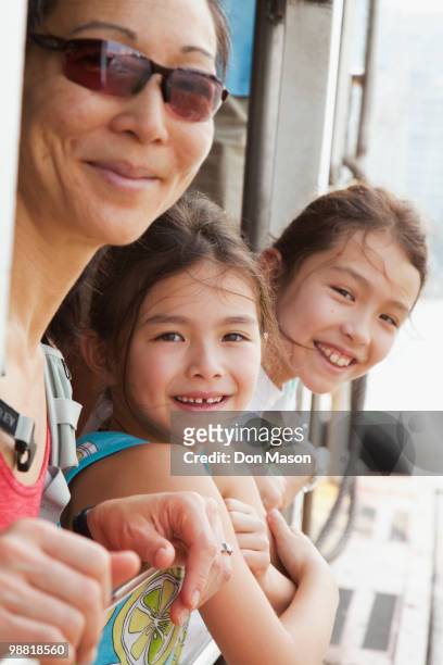mother and daughters riding on boat - don mason stock pictures, royalty-free photos & images