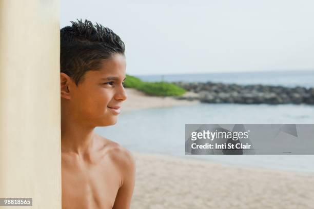 mixed race boy on beach with surfboard - inti st clair stock pictures, royalty-free photos & images