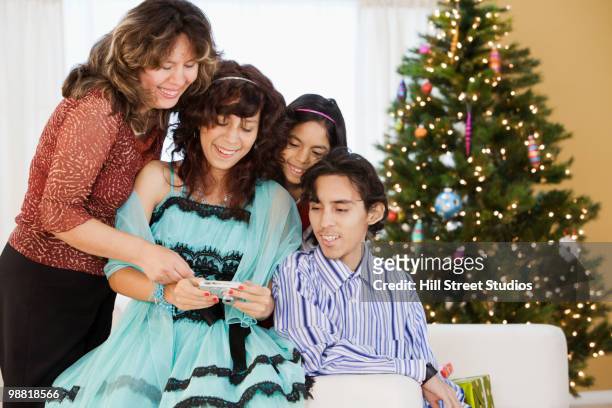 hispanic family looking at christmas pictures - gardena california fotografías e imágenes de stock