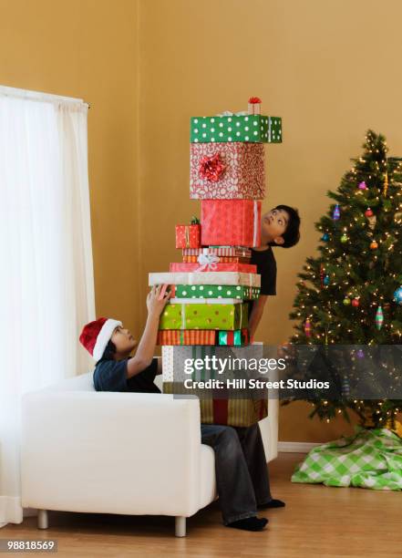 filipino boys sitting with stack of christmas gifts - gardena california stock pictures, royalty-free photos & images