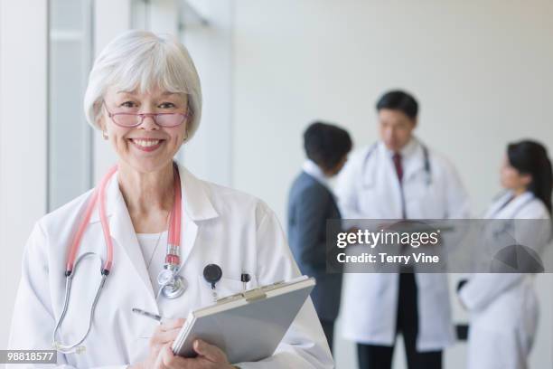 mixed race doctor holding medical chart - terry fair stock pictures, royalty-free photos & images