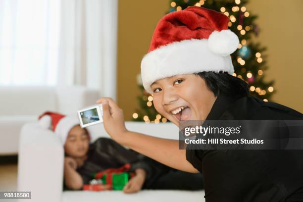 filipino boy taking picture of brother at christmas time - gardena california fotografías e imágenes de stock