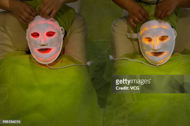 Women have facial care products applied on their faces during facial beauty treatments at a beauty salon on May 25, 2018 in Zhuji, Zhejiang Province...